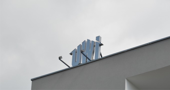 Litery przestrzenne na budynek po zmroku podświetlane są dwoma reflektorami. litery przestrzenne na budynek UWI_02